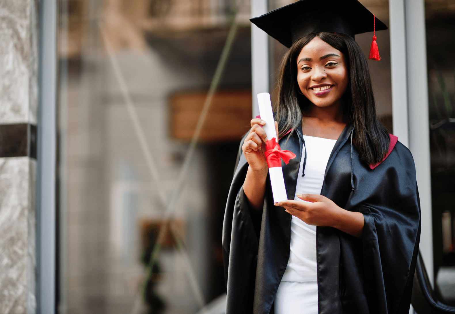 Young female graduate holding her diploma outdoors